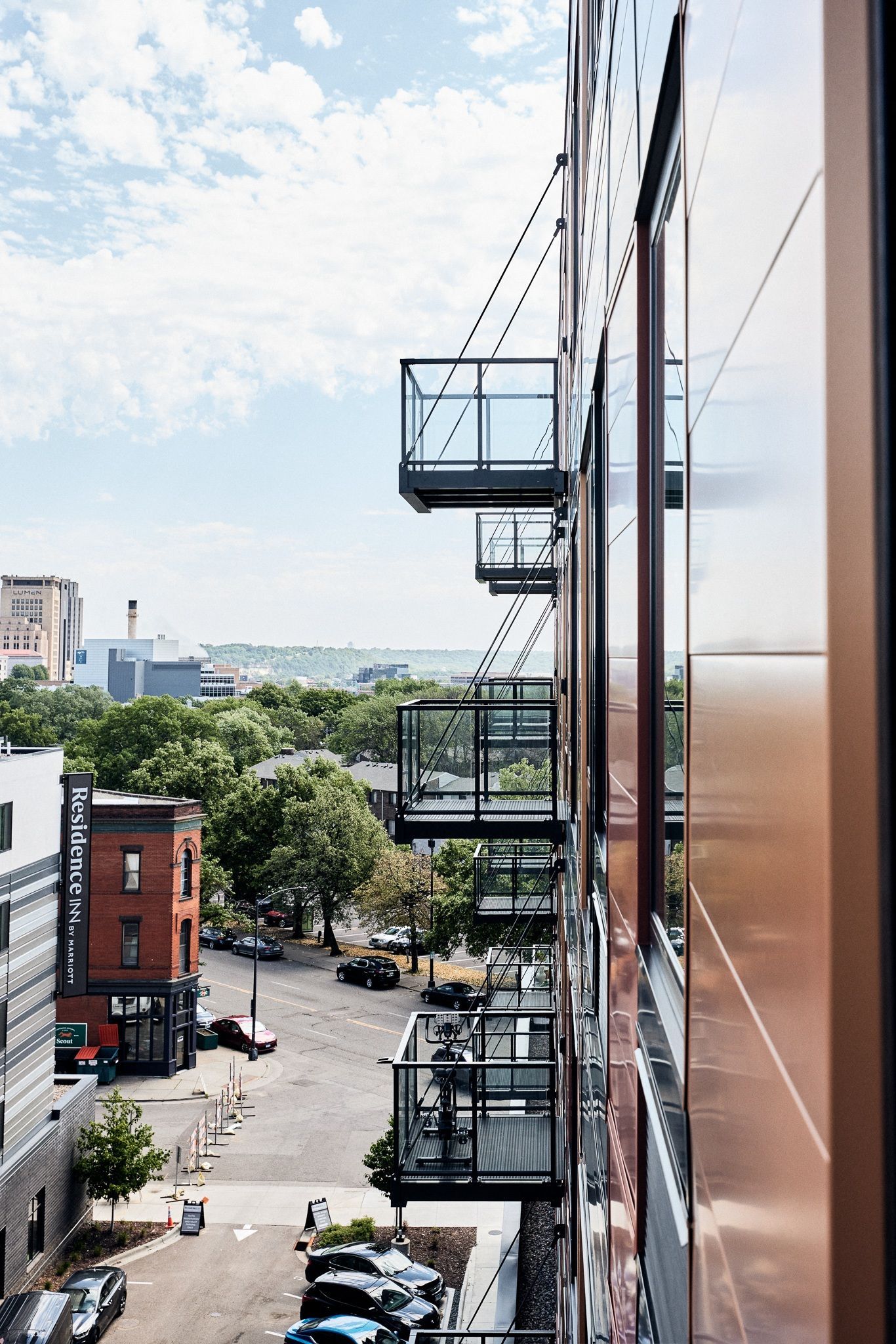 Exterior view of a modern apartment building with glass balconies along the facade.