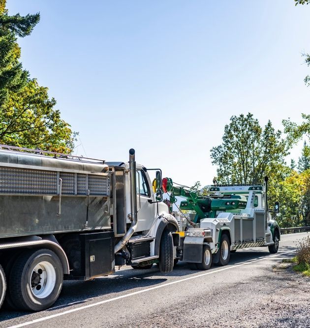 Green And White Powerful Mobile Road Assistant Big Rig Towing Truck Tow Another Broken Semi Truck Transporting It To Repair Shop — Grafton Heavy Towing In Grafton NSW