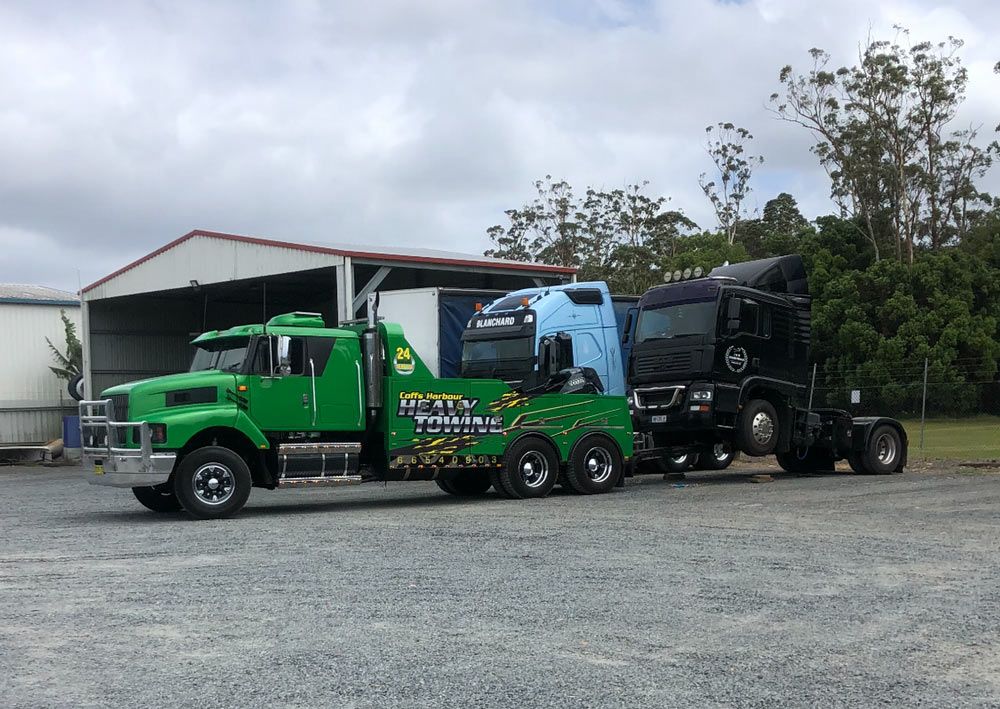Green Towing Truck Towed The Heavy Black Big Truck— Grafton Heavy Towing In Grafton NSW