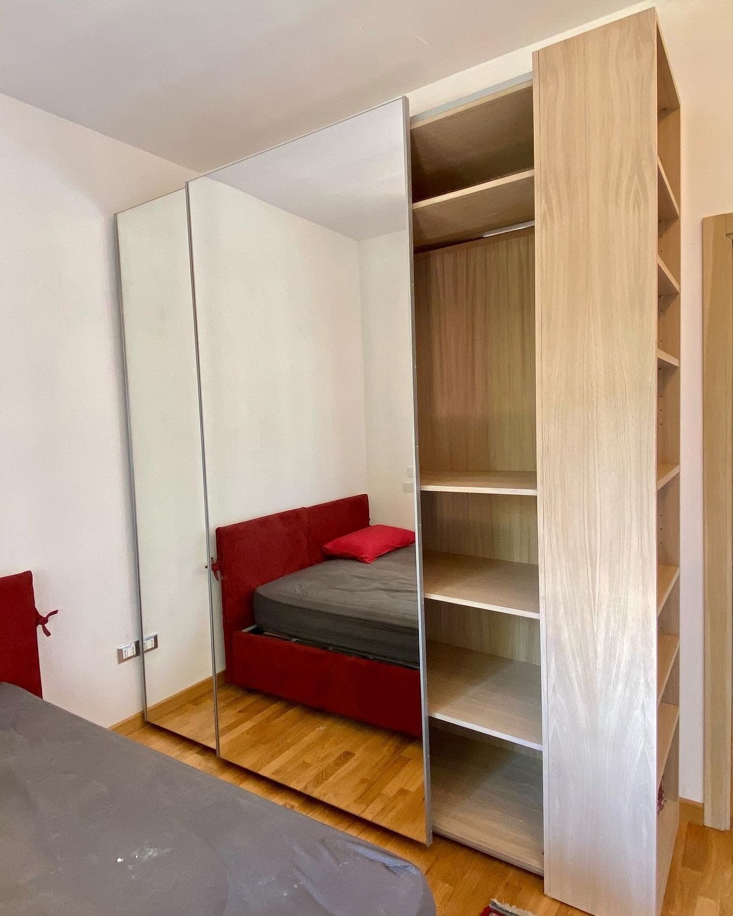 Armadio in rovere con ante scorrevoli e specchi integrati. Con appendi abiti e ripiani.