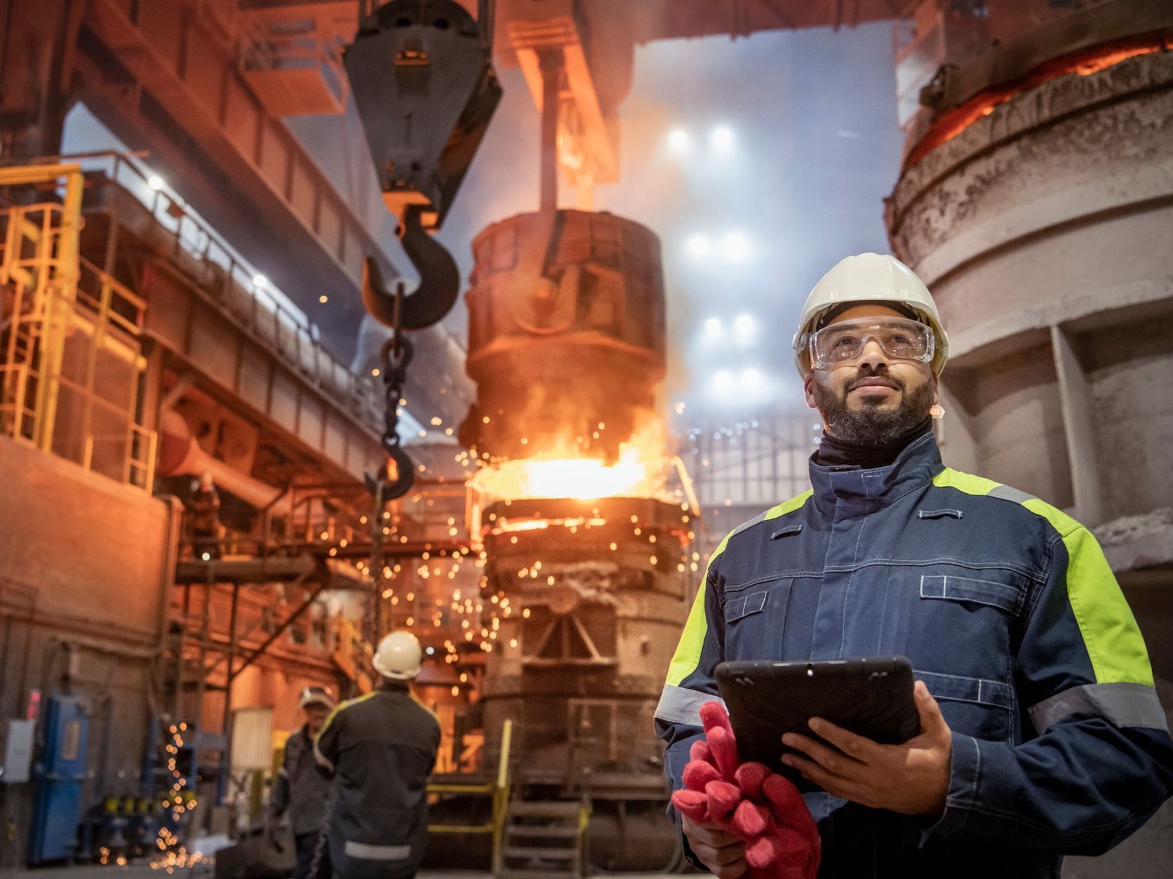 Un uomo tiene in mano un tablet in una fabbrica.