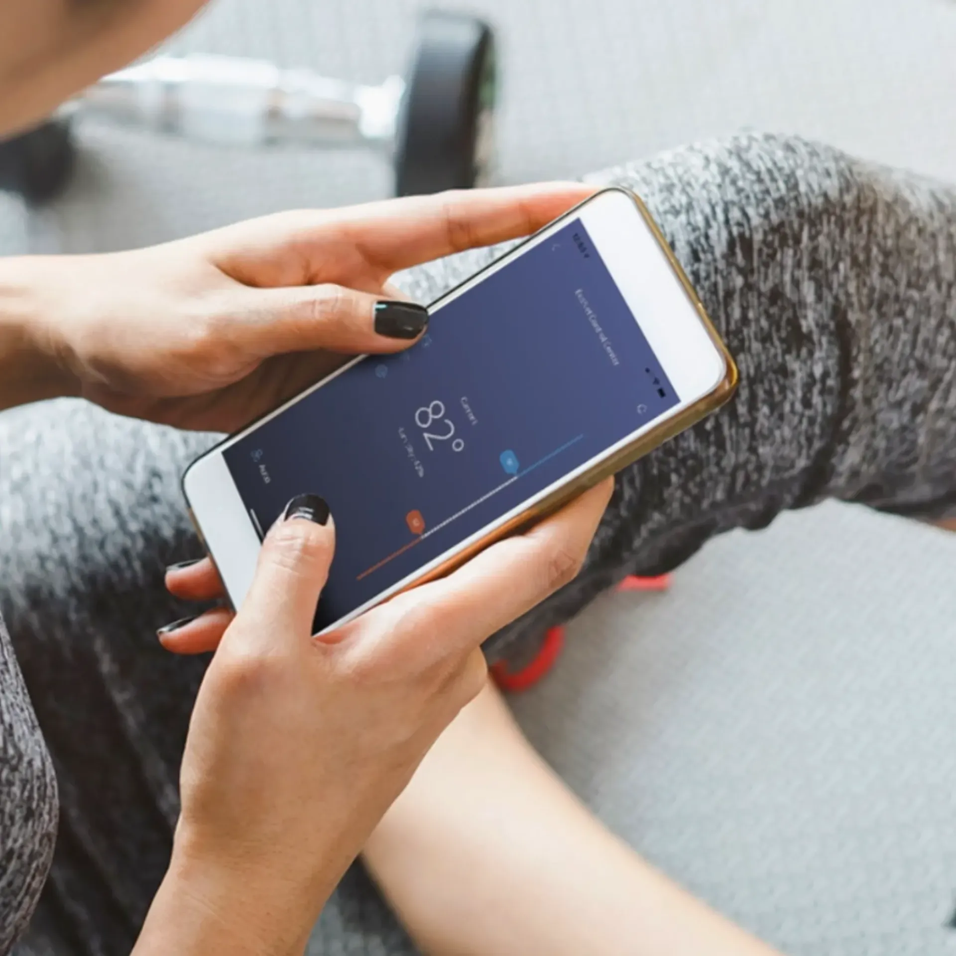 Kingdom Air LLC - A woman is holding a cell phone that says 82 degrees on the screen