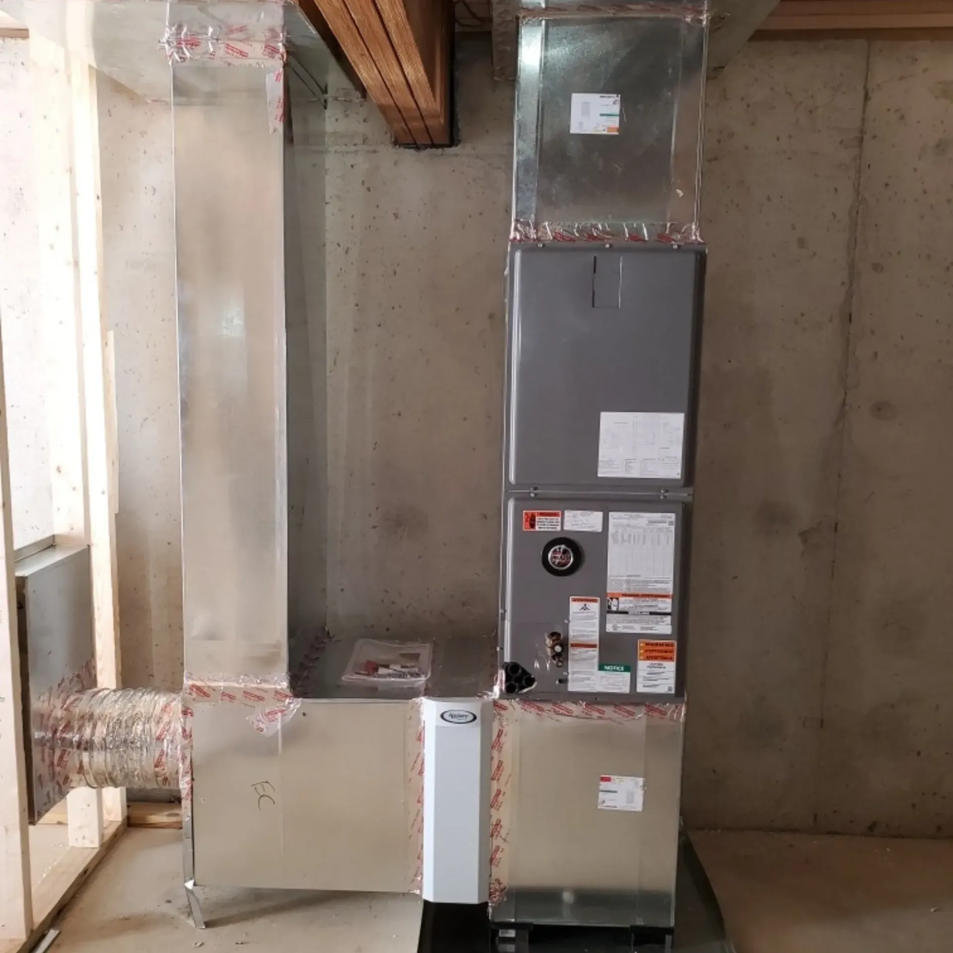 Kingdom Air LLC - A stainless steel air conditioner is sitting in a room next to a concrete wall.