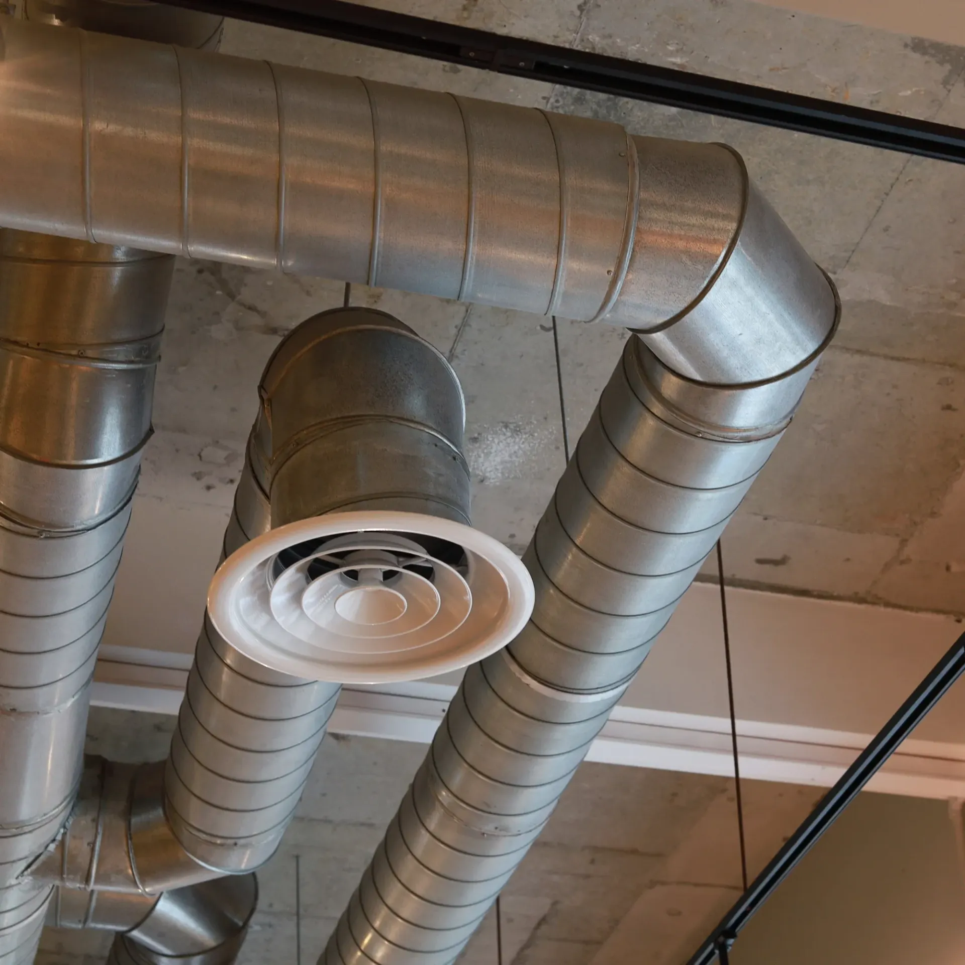 Kingdom Air LLC - A bunch of metal pipes are hanging from the ceiling.