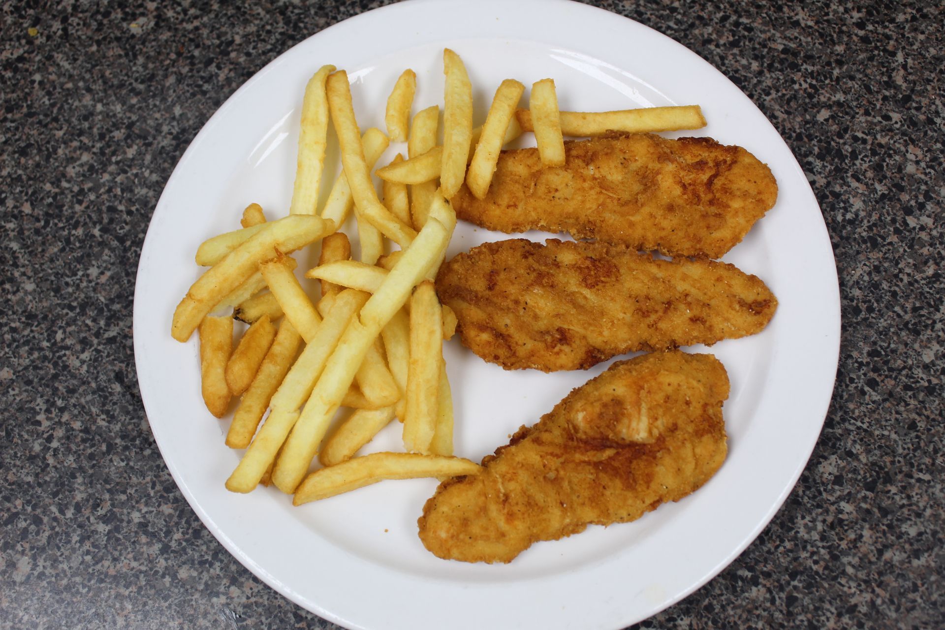Plate of fried chicken tenders and french fries.