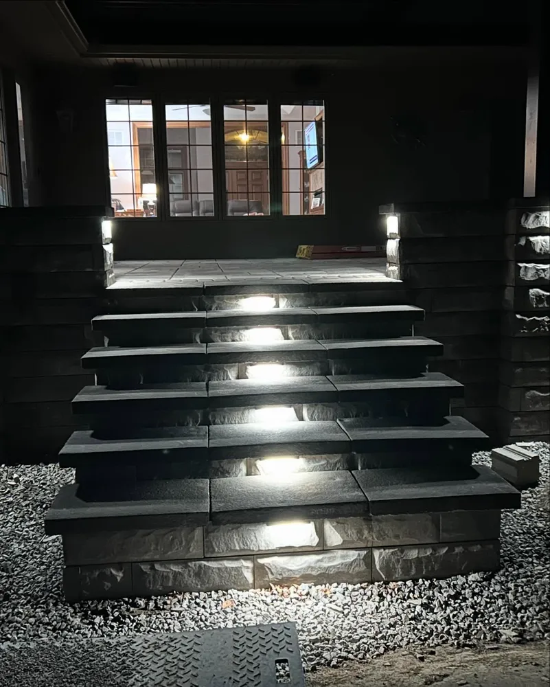 The stairs are lit up at night and there is a window in the background.