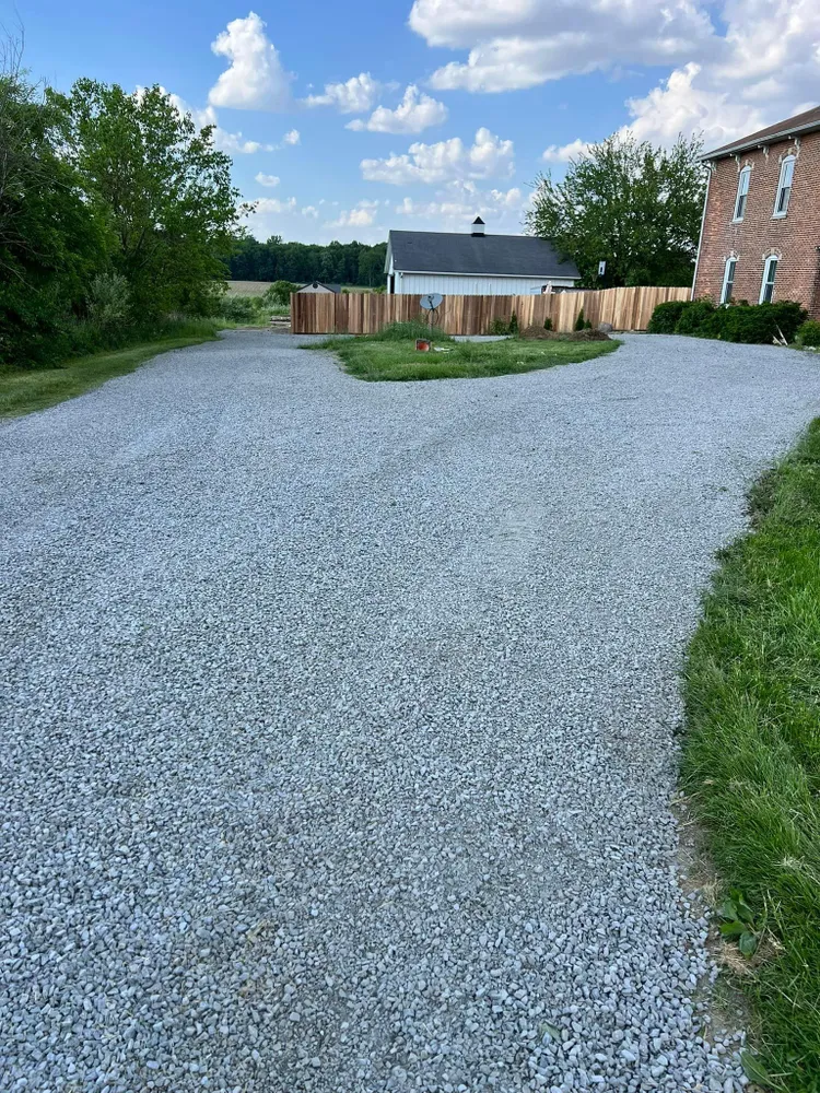 A gravel driveway leading to a brick house