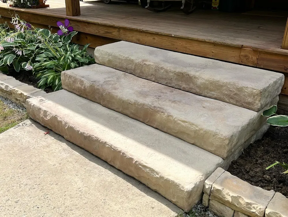 A set of stone steps leading up to a wooden deck.