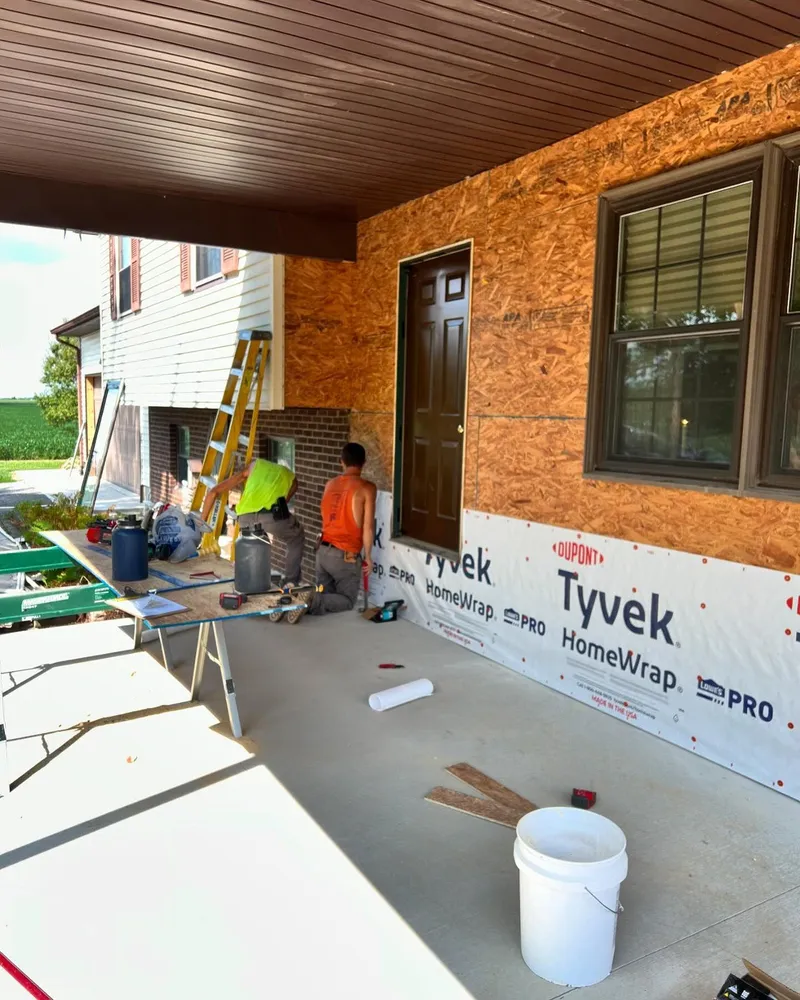 A group of men are working on the side of a house.