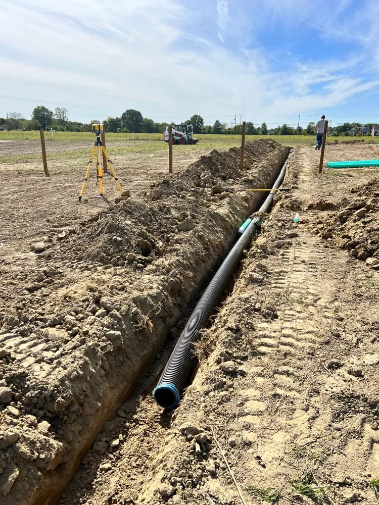 A pipe is being installed in the dirt on a construction site.