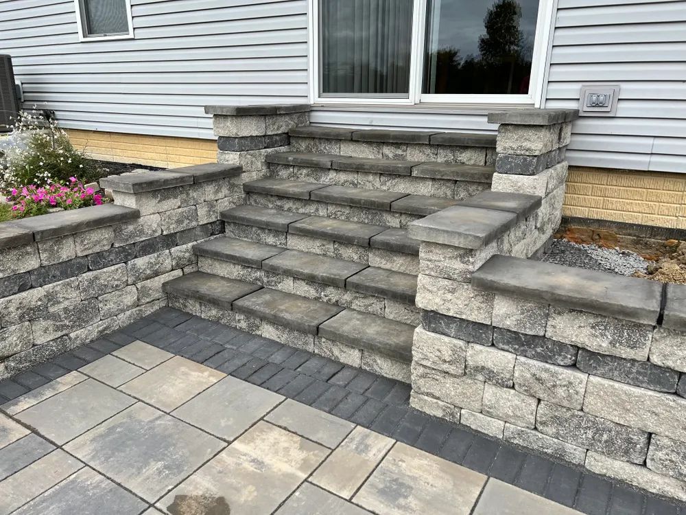 A set of stairs leading up to a patio next to a house.