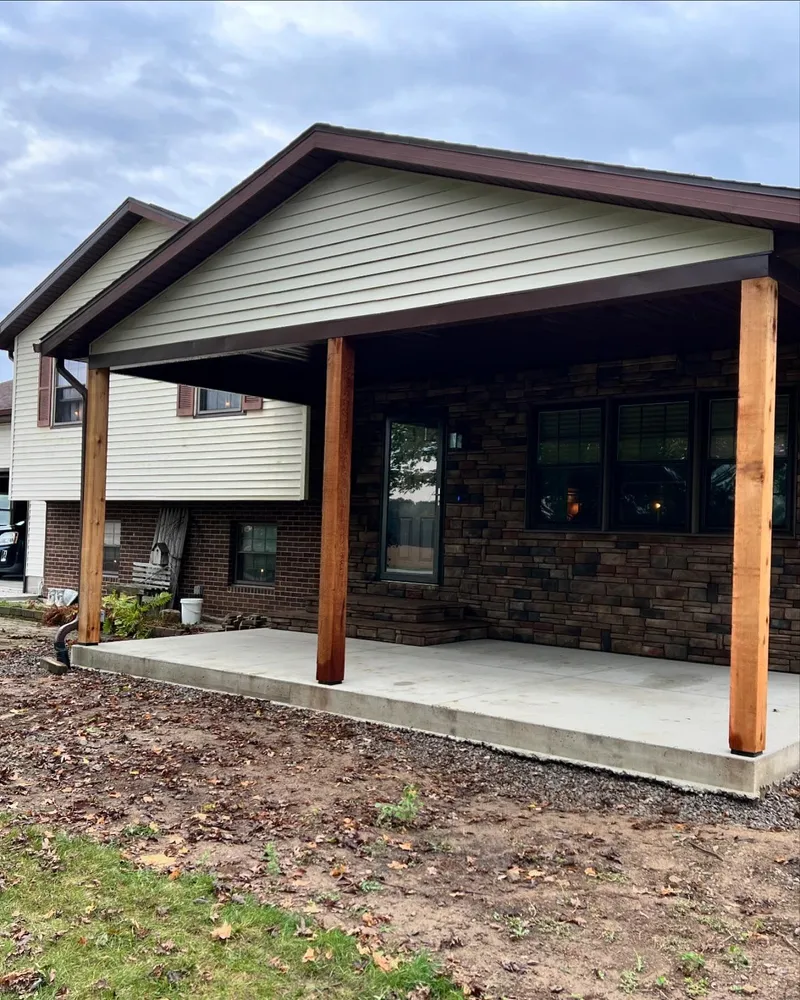 A brick house with a covered porch and wooden posts