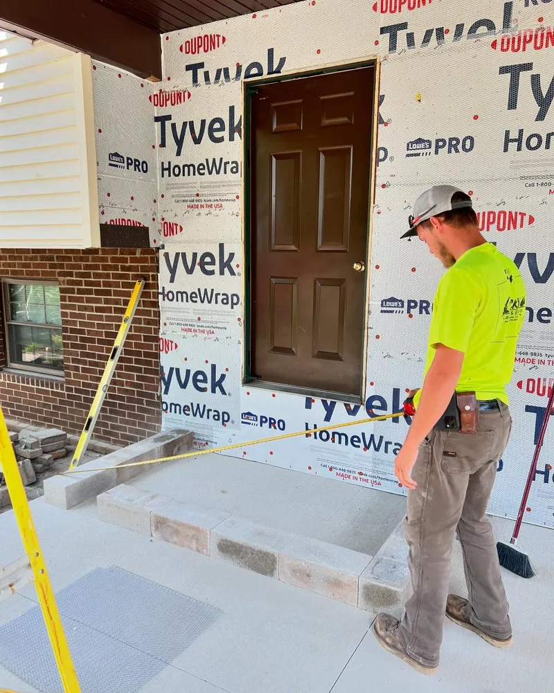 A man is measuring a door with a tape measure.