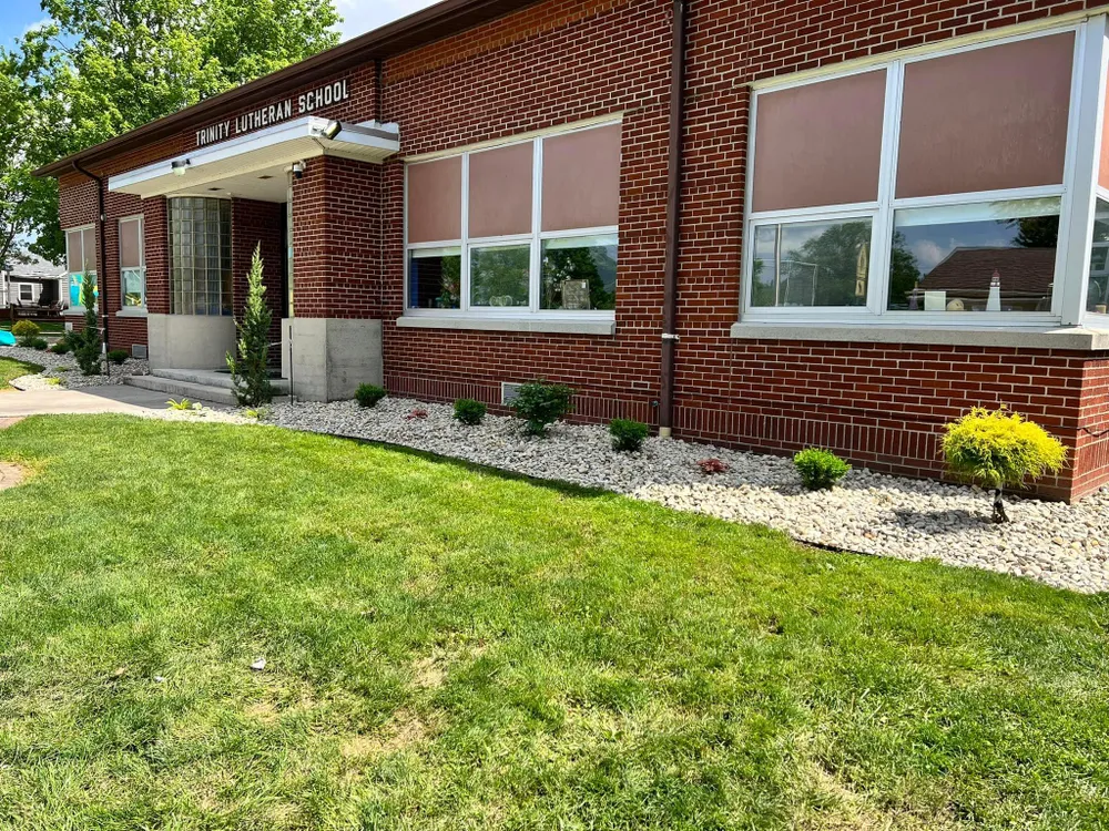 A brick building with a lush green lawn in front of it.