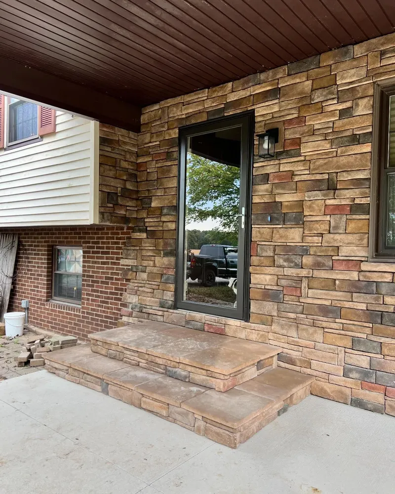 A brick house with a sliding glass door and steps