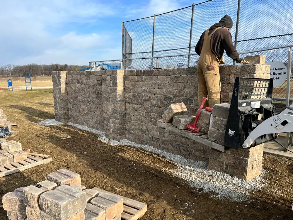 A man is standing on top of a pile of bricks.