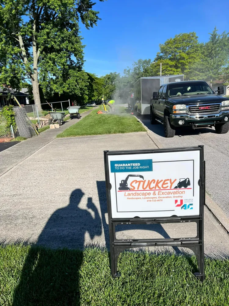 A truck is parked on the side of the road next to a sign that says stuckey landscape & irrigation.
