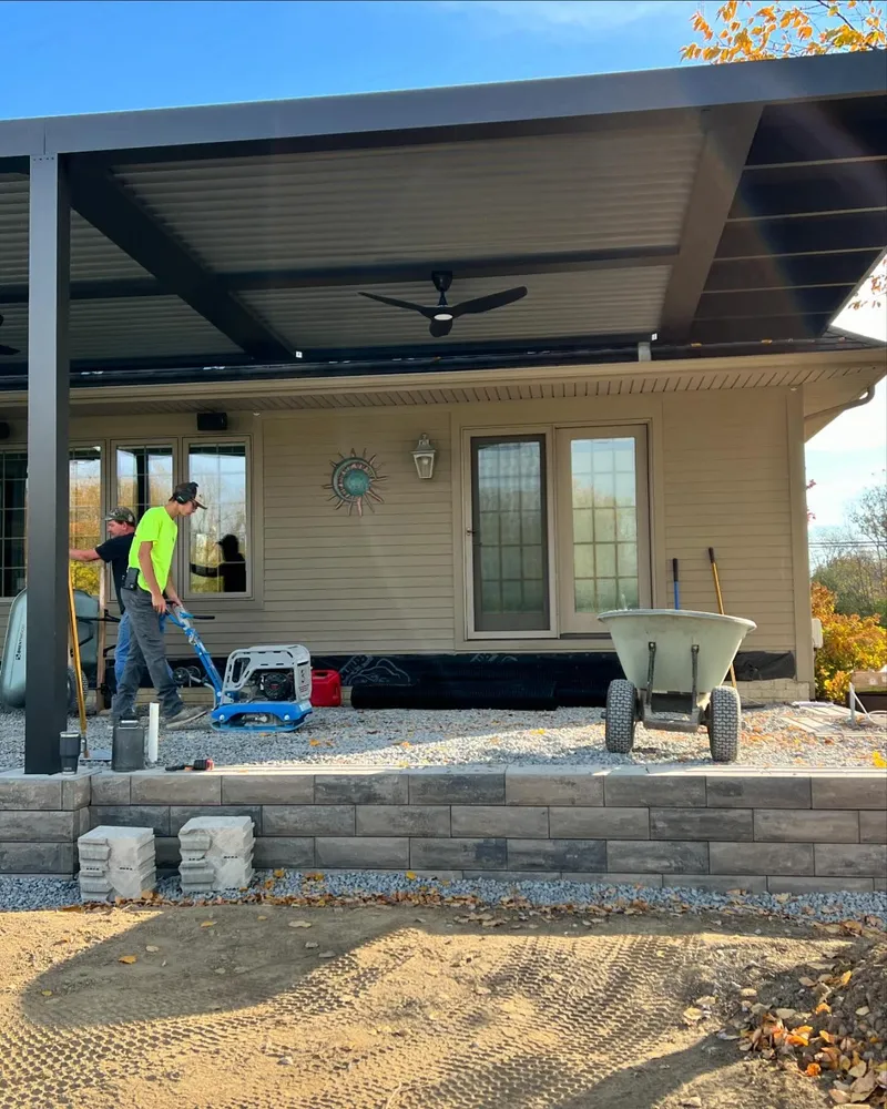A man is standing on a porch next to a house.