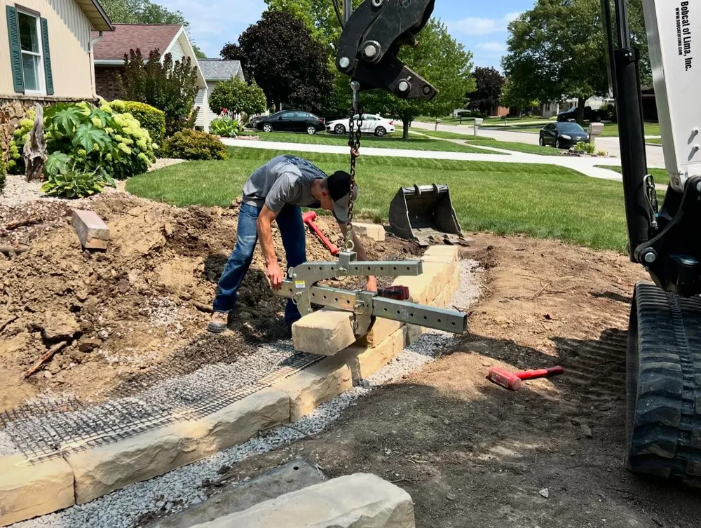 A man is working on a fence in front of a house.