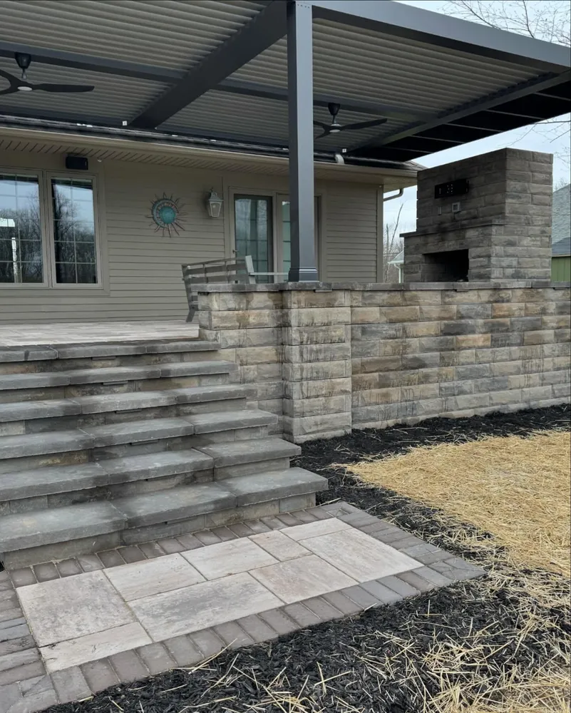 A house with a brick wall and stairs leading up to it