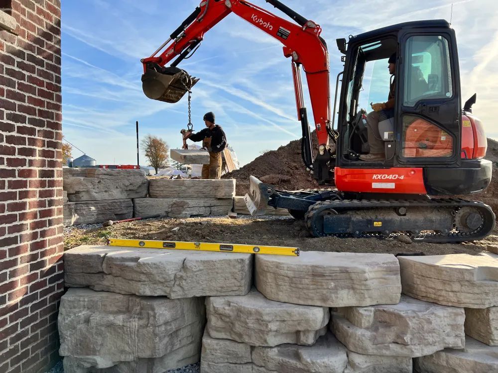 An excavator is digging a hole in a pile of rocks.