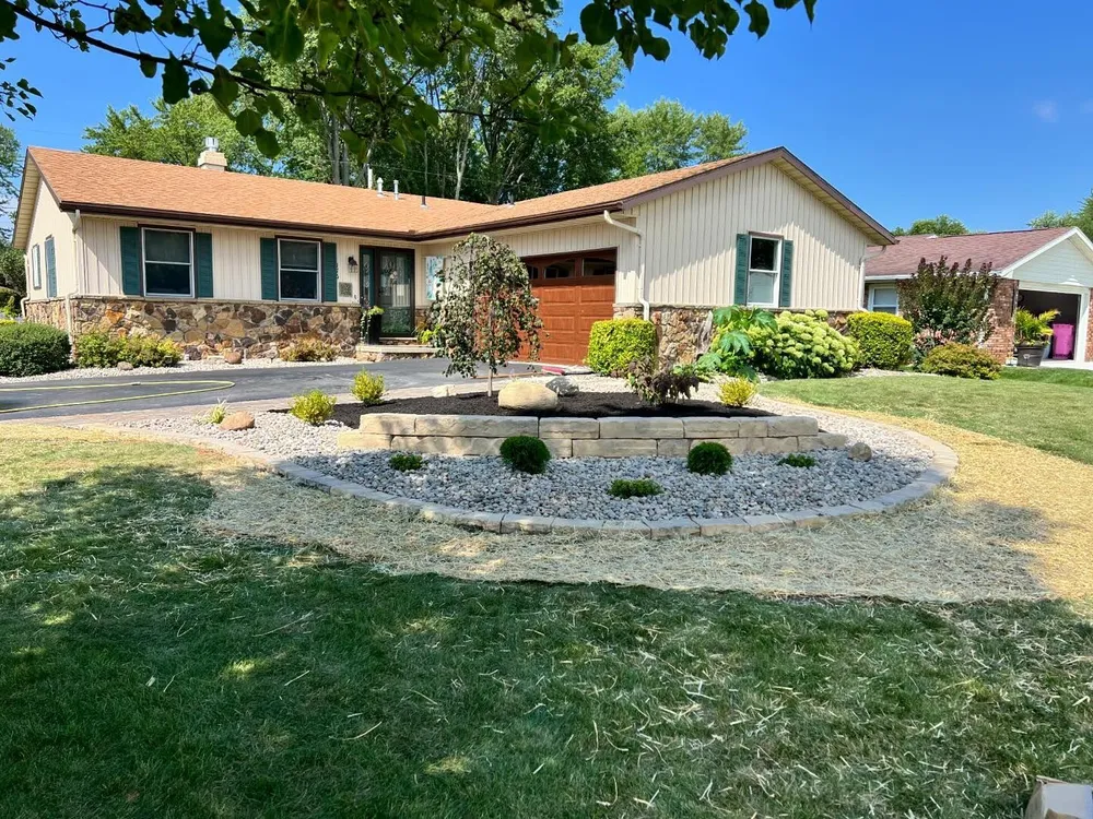 A white house with a brown roof and a driveway