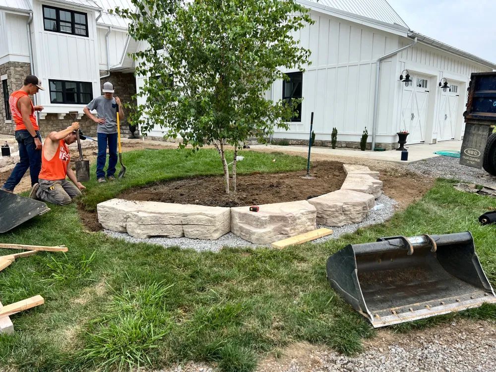 A group of men are working on a landscaping project in front of a house.