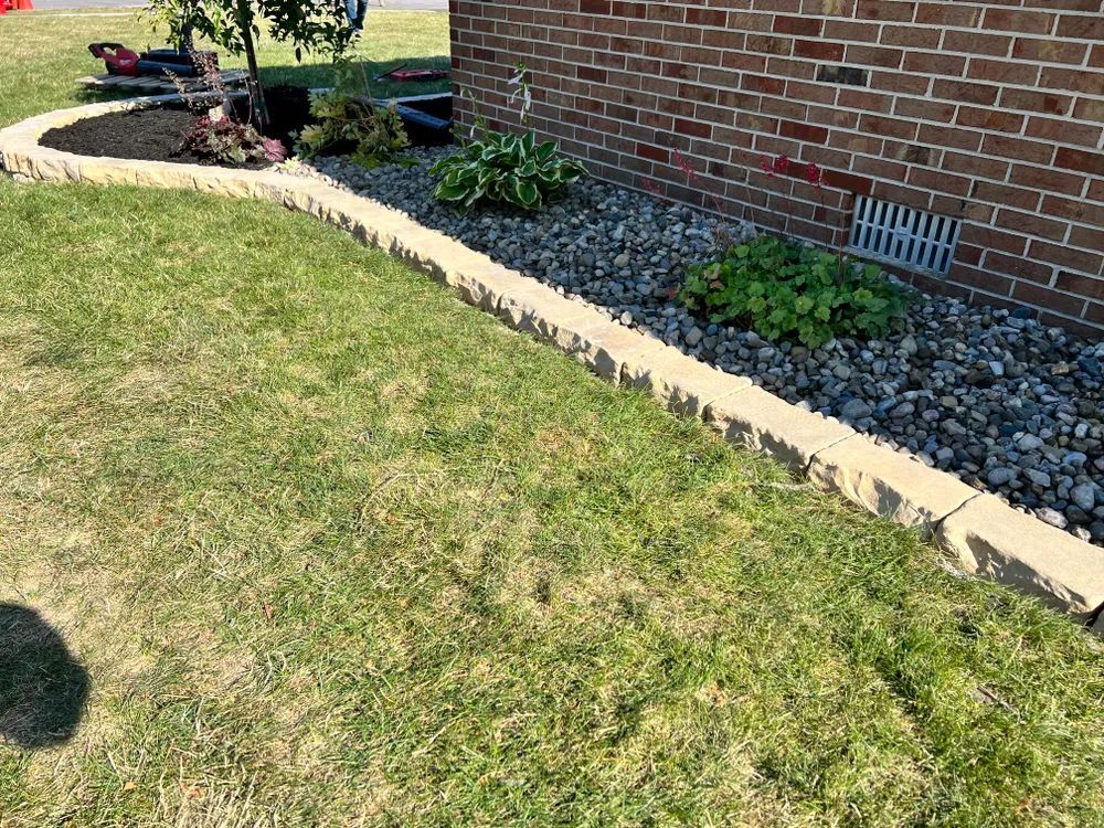 A brick house with a concrete curb in front of it.