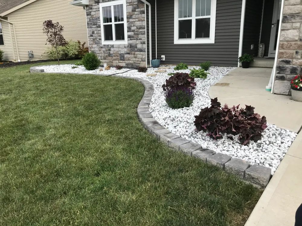 A house with a lush green lawn and white gravel in front of it.