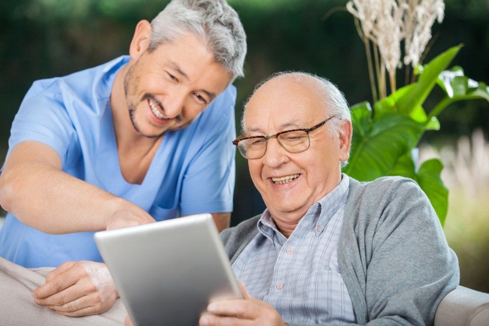 dipendente del centro con anziano davanti il tablet