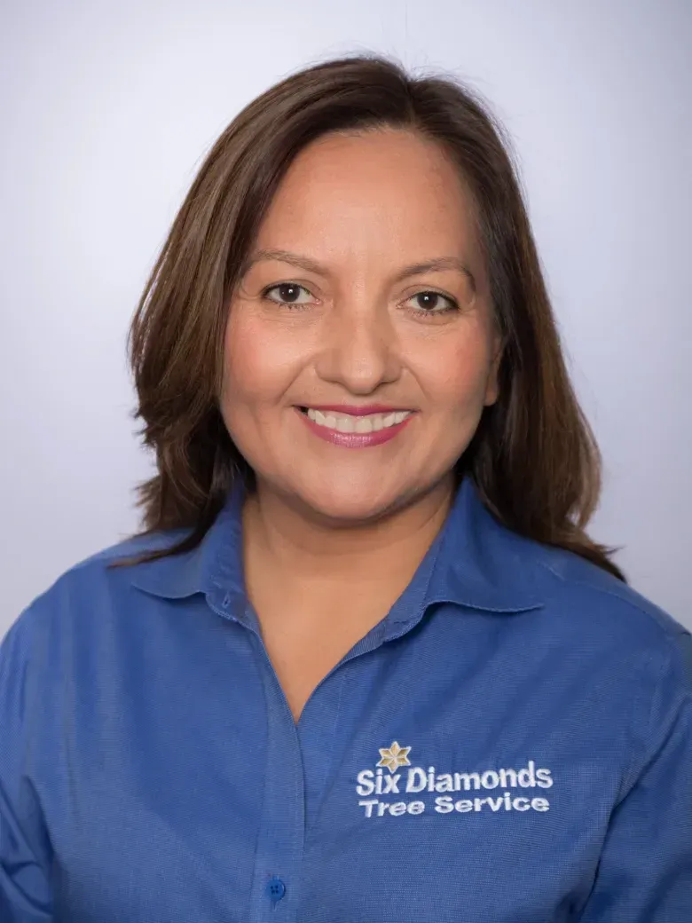 Our President, Mria wearing a blue shirt that says six diamonds tree service
