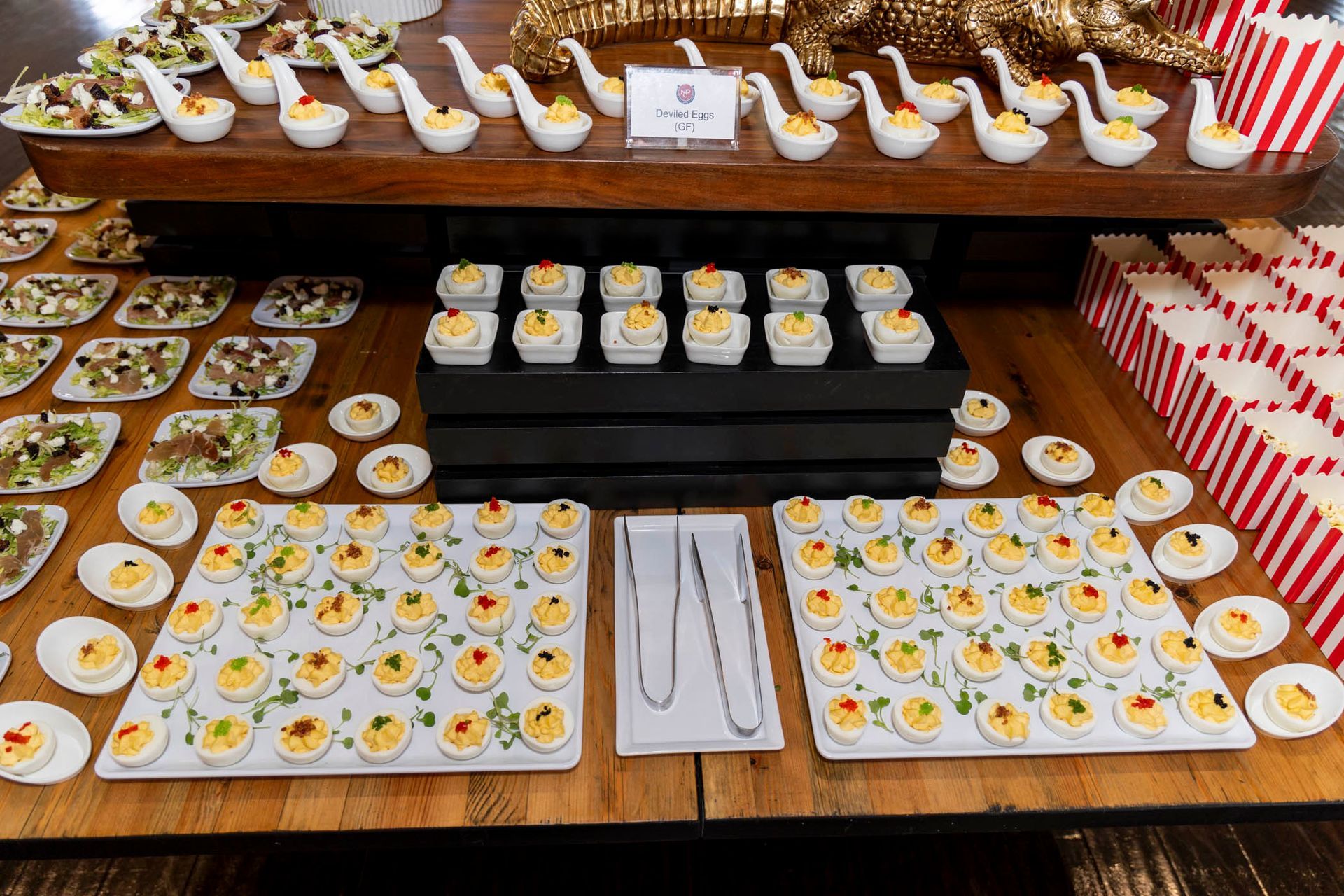 A wooden table topped with plates of food and bowls of food.