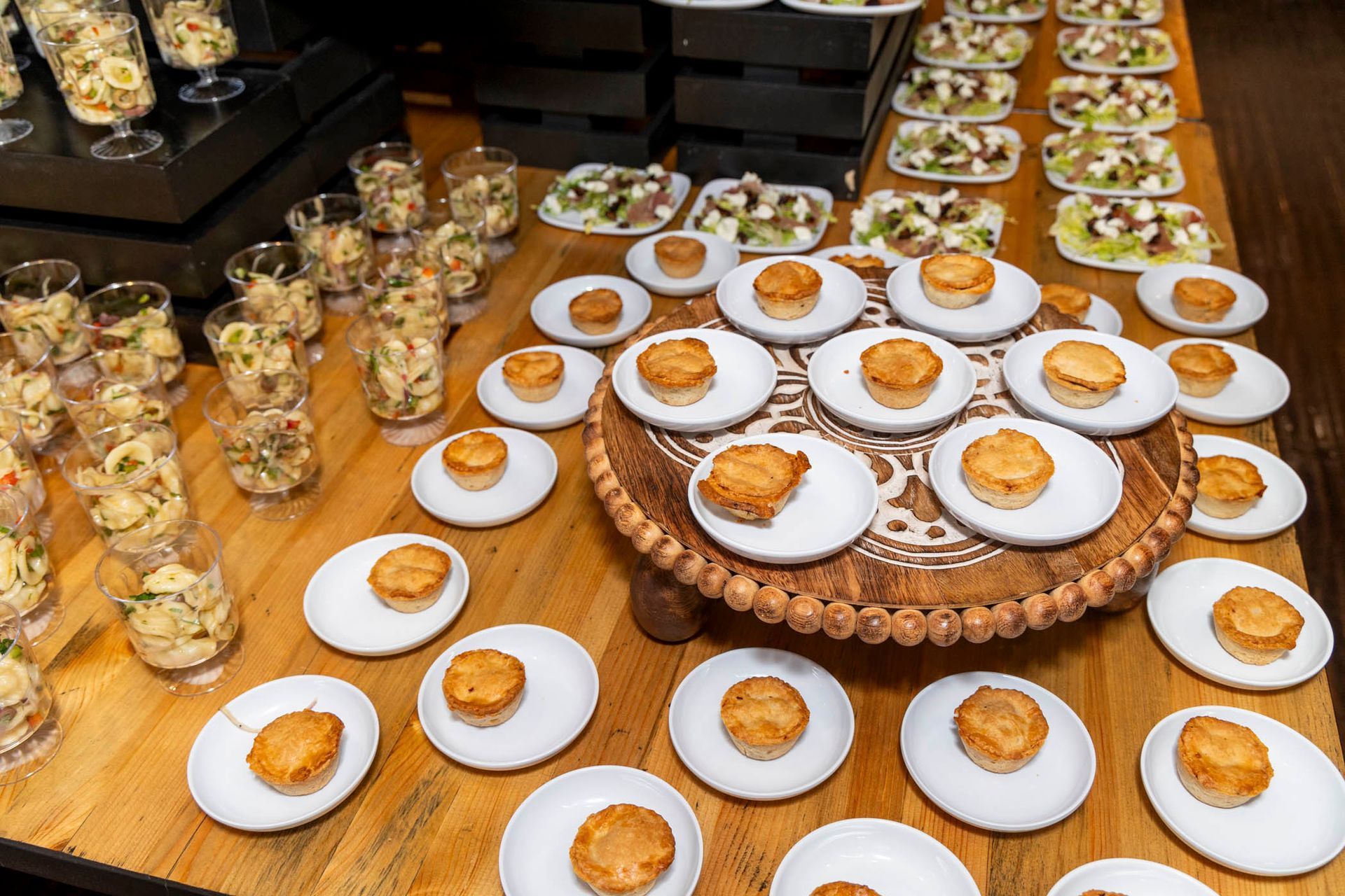 A wooden table topped with plates and cups of food.