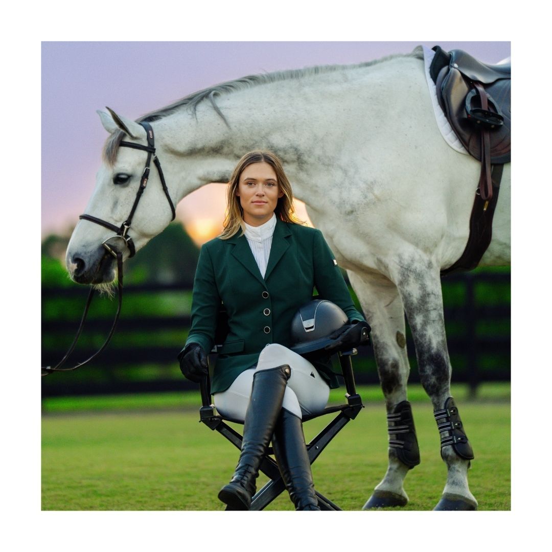 a woman is sitting in a chair next to a white horse .