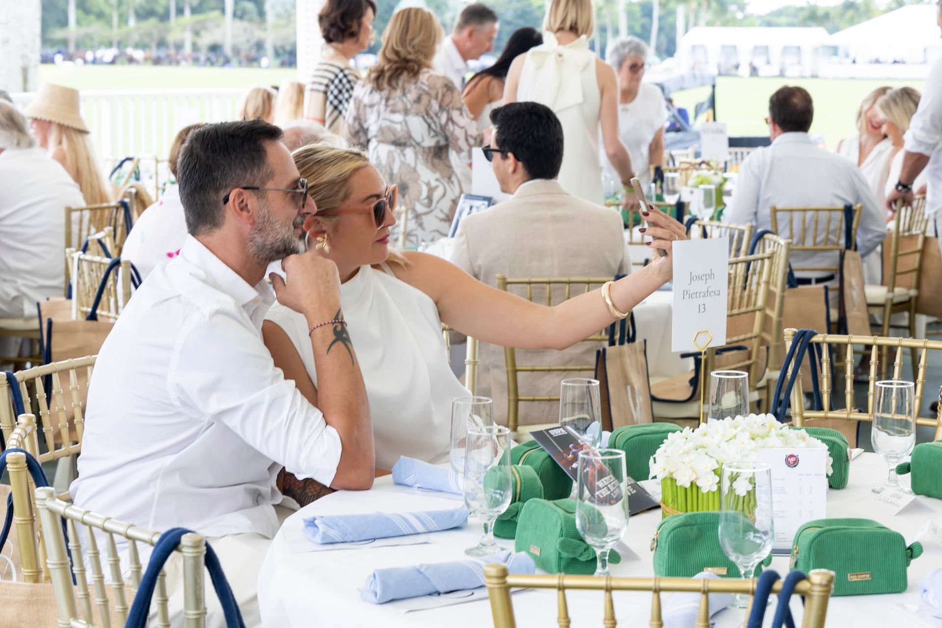 A man and a woman are sitting at a table at a party.