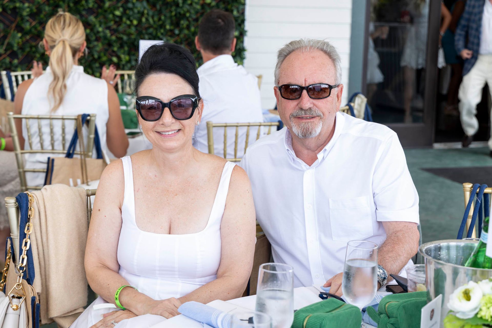 A man and a woman are sitting at a table with glasses of water.