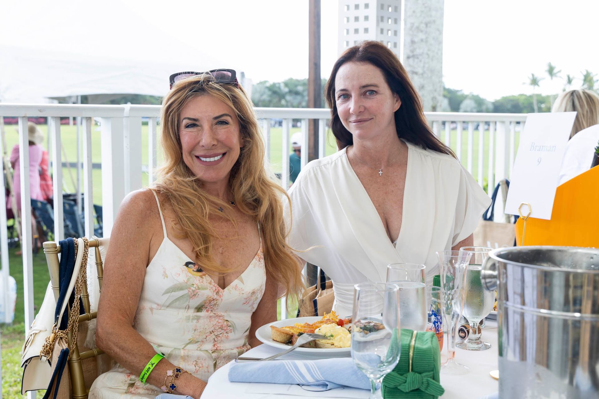 Two women are sitting at a table with a plate of food.
