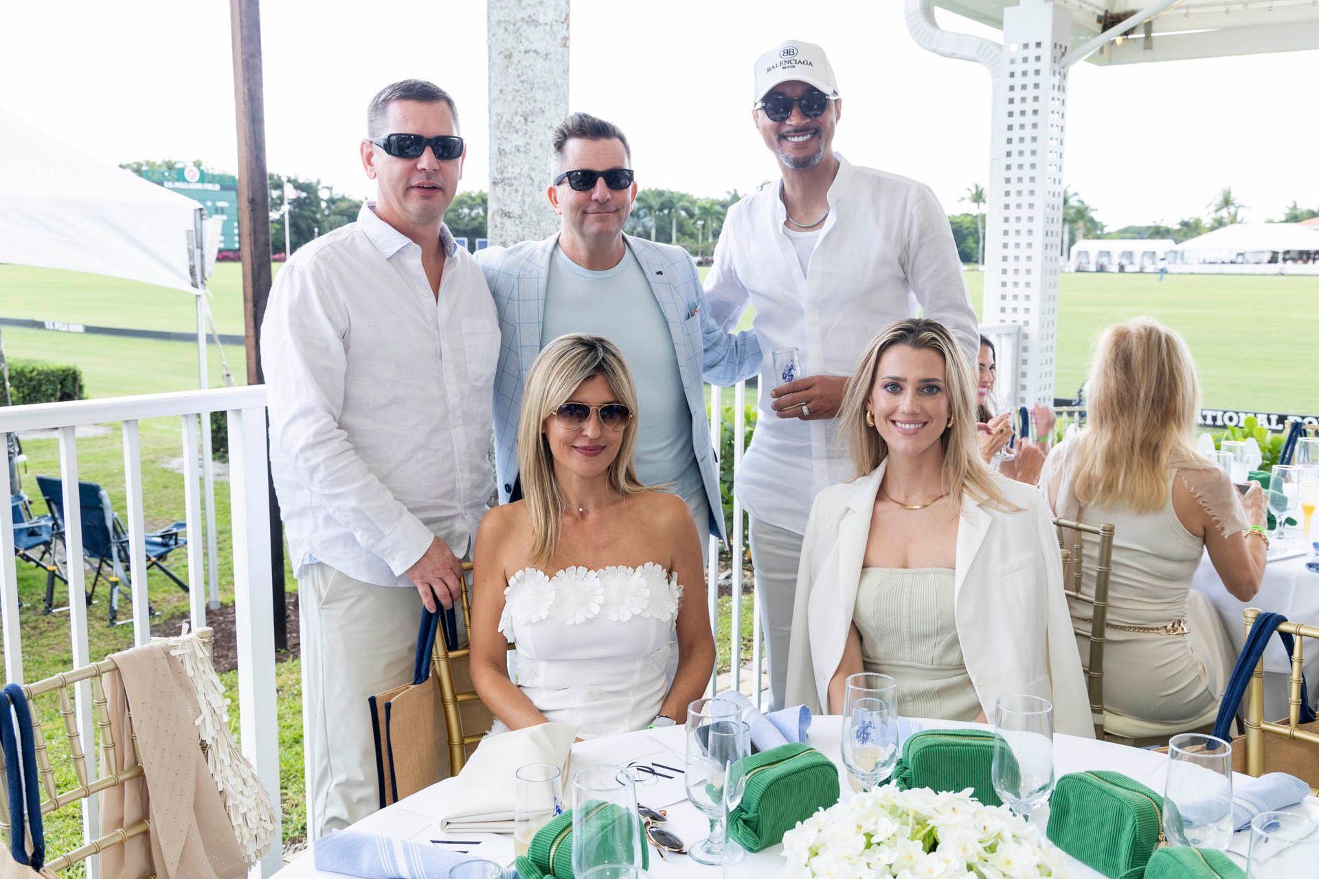 A group of people are posing for a picture while sitting at a table.