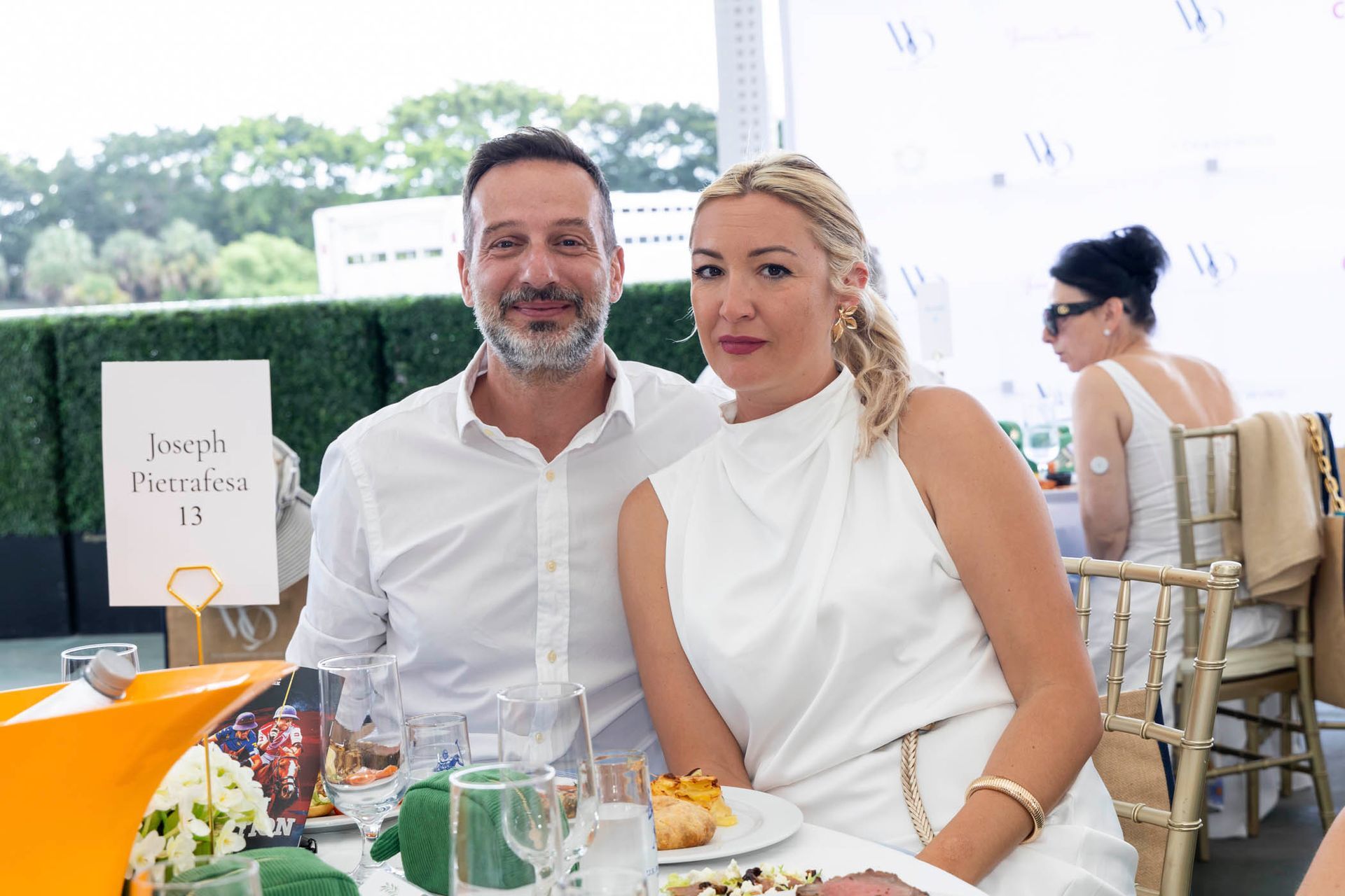 A man and a woman are sitting at a table with plates of food.