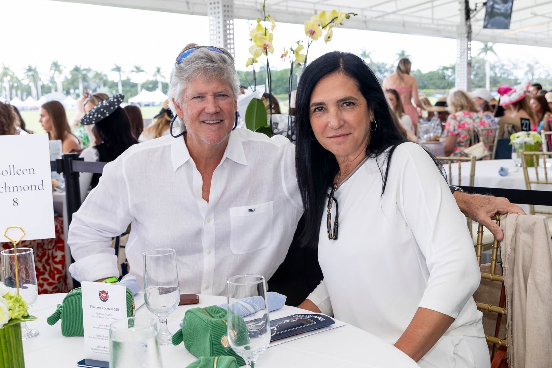 A man and a woman are posing for a picture while sitting at a table.
