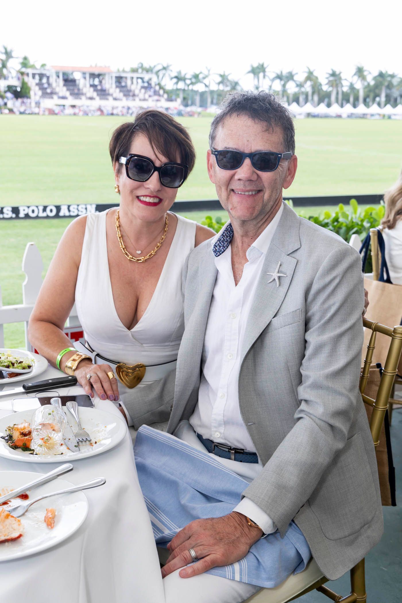 A man and a woman are sitting at a table with plates of food.