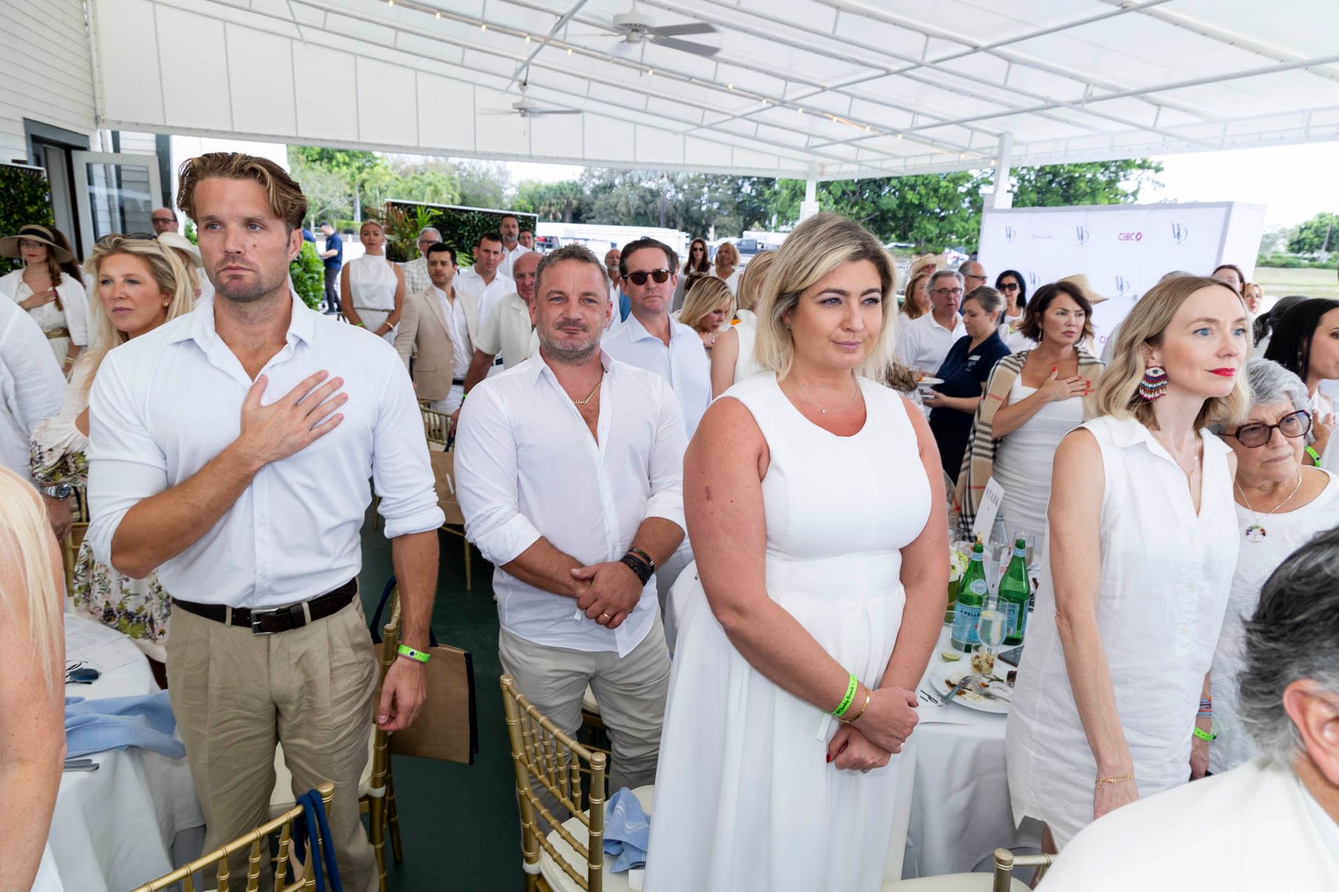A group of people wearing white standing in a room.