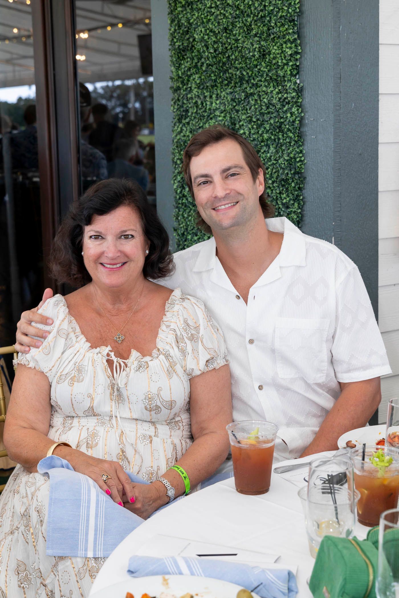 A man and a woman are sitting at a table with drinks.