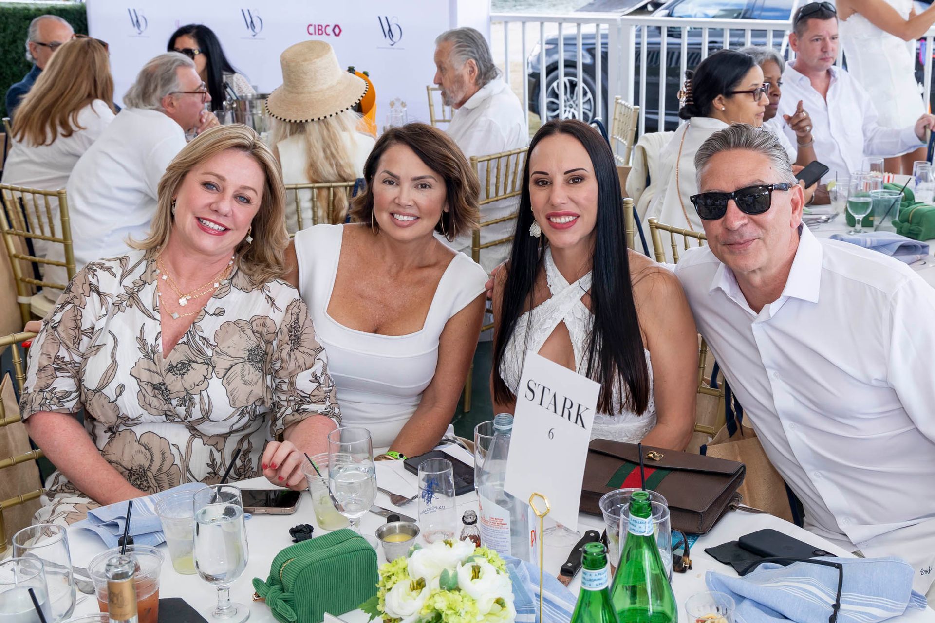 A group of people are sitting at a table posing for a picture.