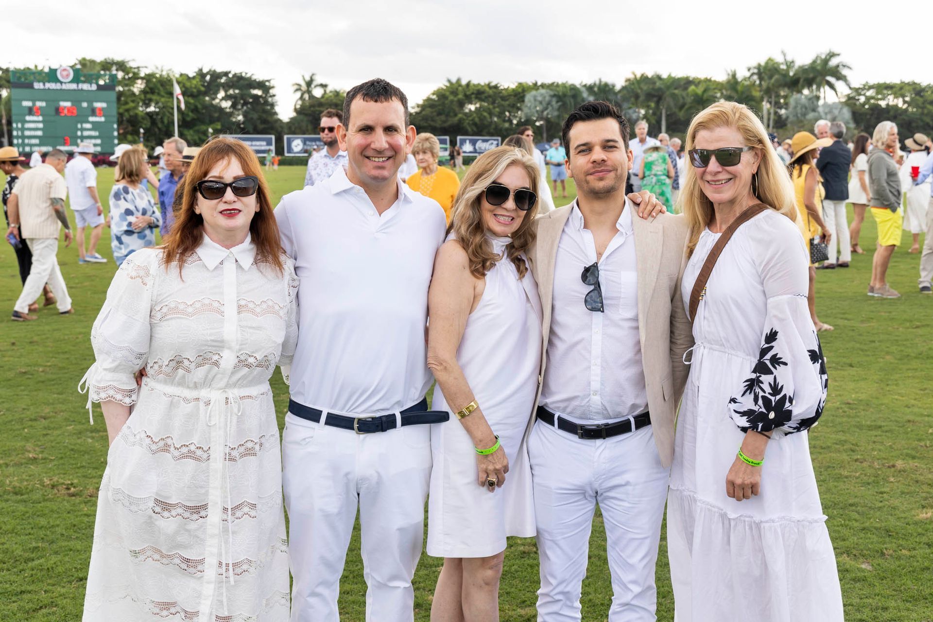 A group of people in white clothes are posing for a picture on a field.