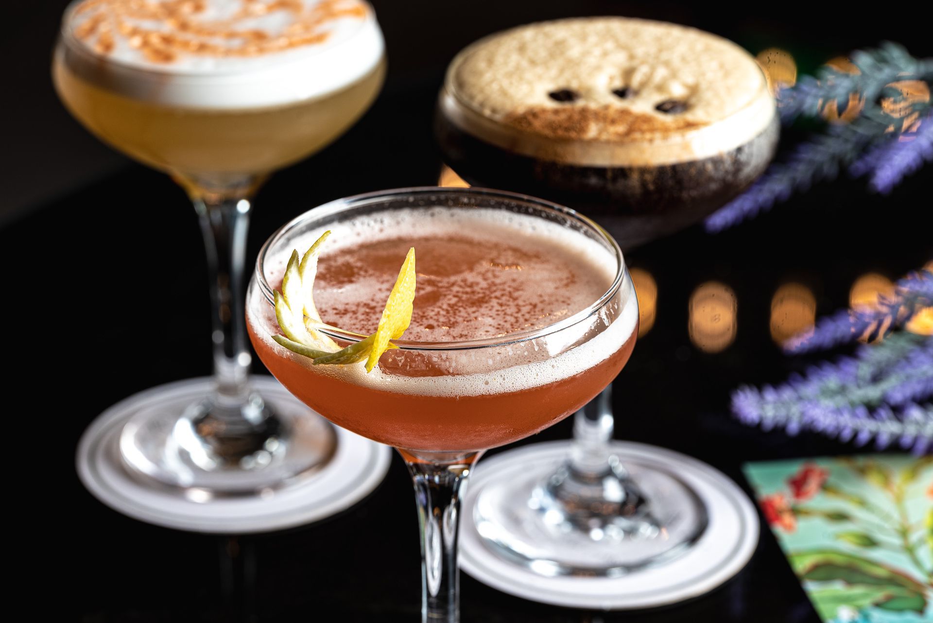 Three different types of cocktails are sitting on a table.