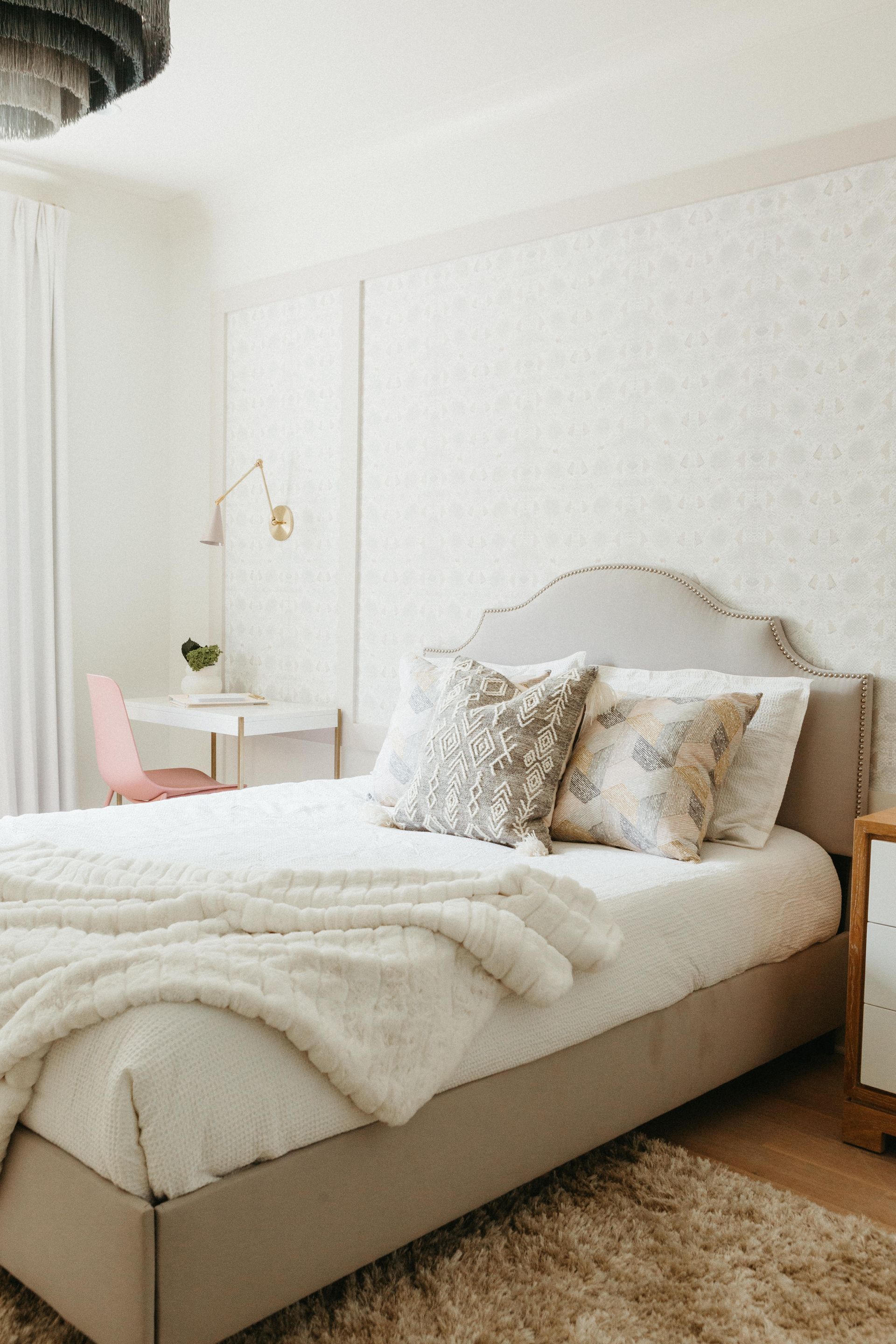 A Bedroom With A Bed, Desk, Nightstand And Rug