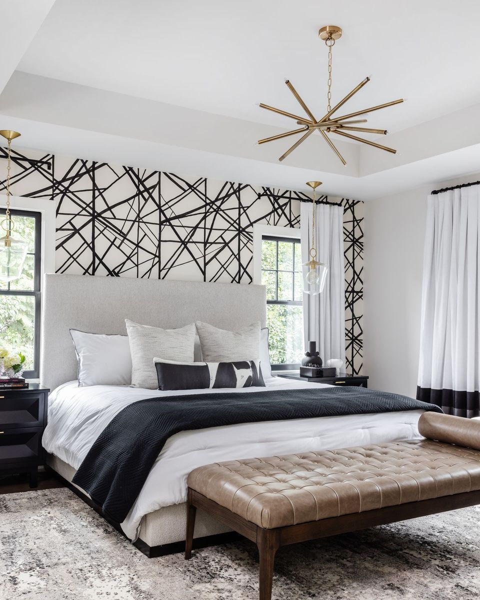 A Bedroom With A Large Bed And A Bench In Front Of It