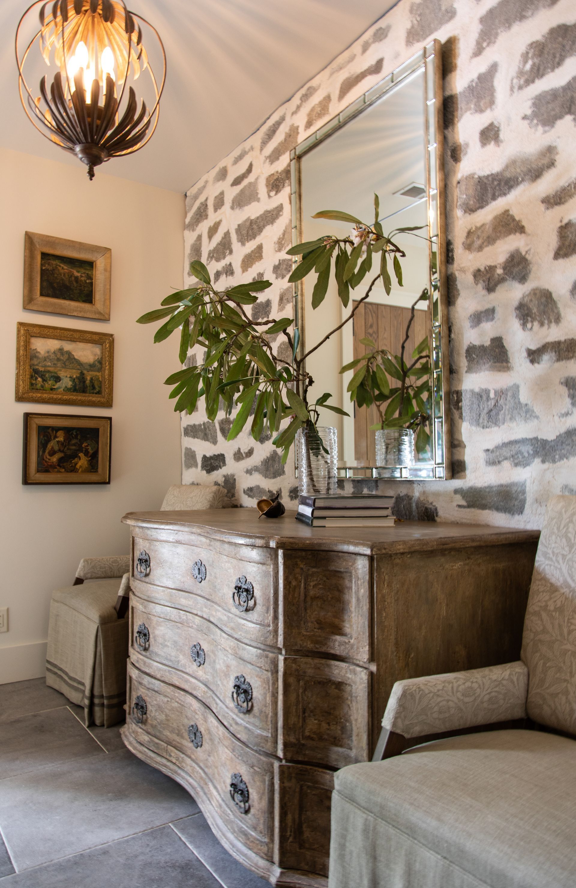 A Living Room With A Dresser, Chair, And Mirror