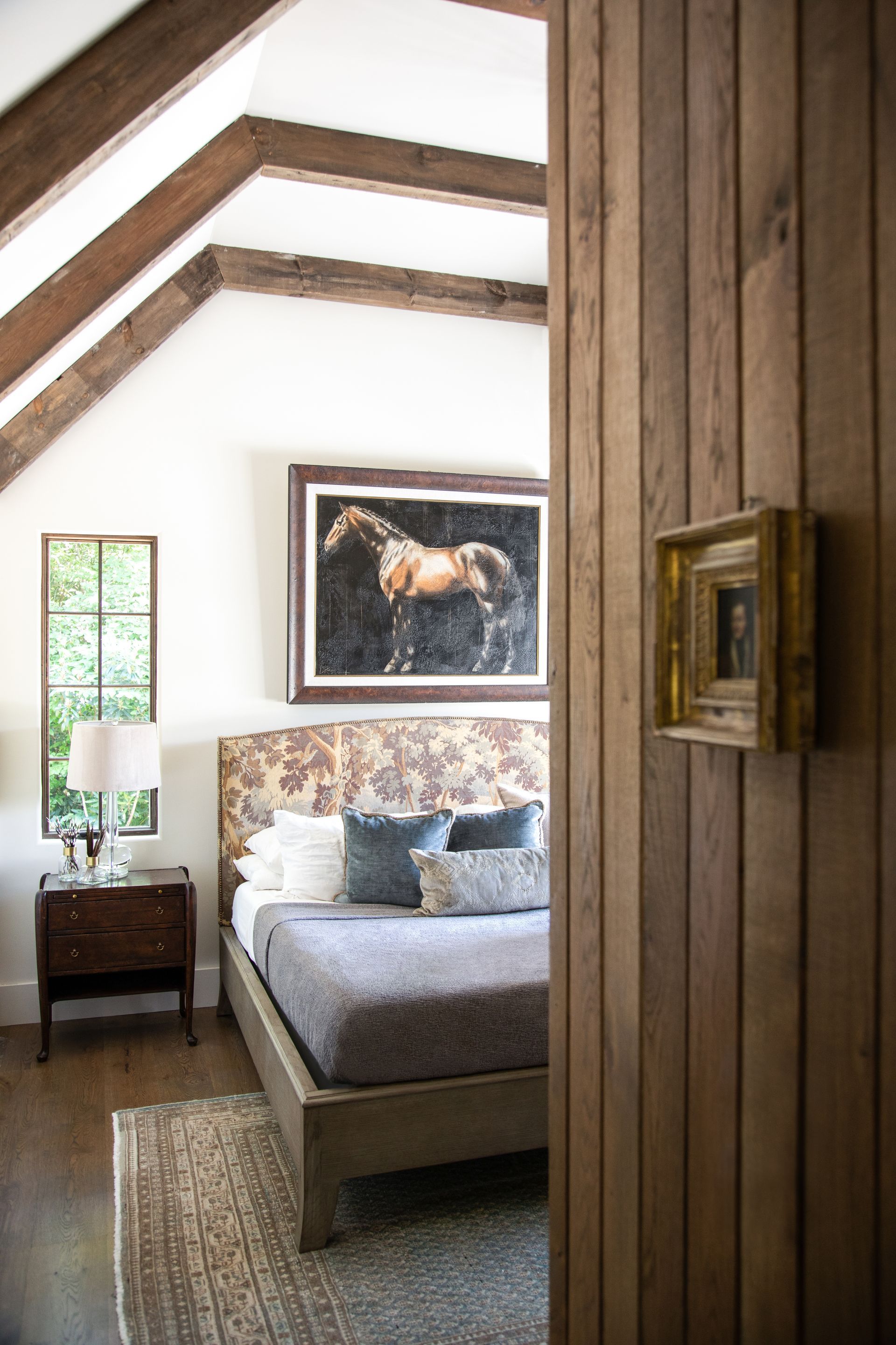 A Bedroom With A Bed And A Painting Of A Horse On The Wall